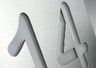 Hausnummer ausgeschnitten und mit Acrylglas hinterlegt.
